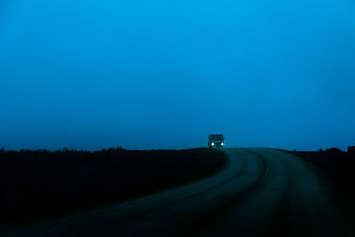 Car on road against clear sky at night