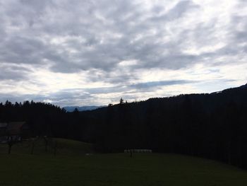 Scenic view of grassy field against cloudy sky