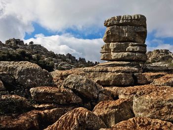 Low angle view of stone wall against cloudy sky