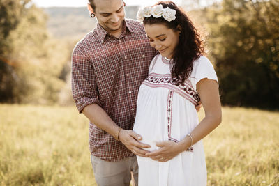 Midsection of couple standing on field