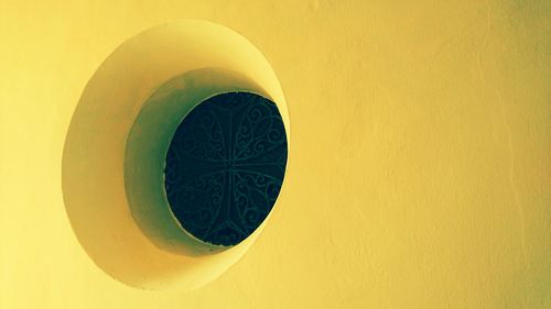 Close-up of yellow object on wall