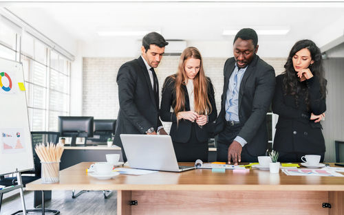 Business people standing by table at office