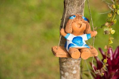 Portrait of stuffed toy on tree trunk