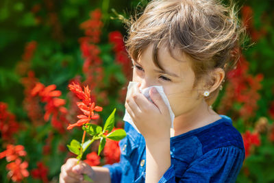 Portrait of young woman blowing flowers