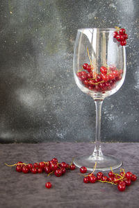 Close-up of cherries on glass against red background