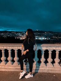 People standing against sky in city at night
