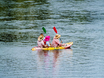 People rowing boat on river