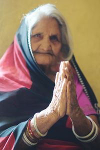 Close-up portrait of woman with hands clasped