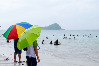Group of people on beach during rainy day