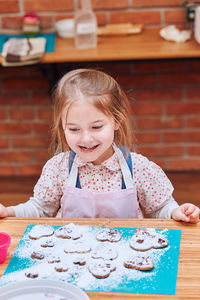 Portrait of a smiling girl sitting on table