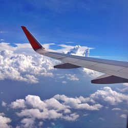 Airplane wing against cloudy sky