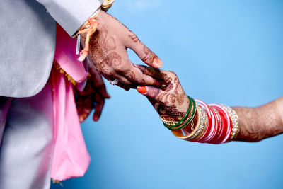 Midsection of man holding woman with umbrella