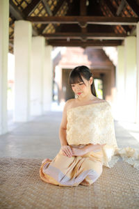 Smiling woman in traditional clothing sitting in temple