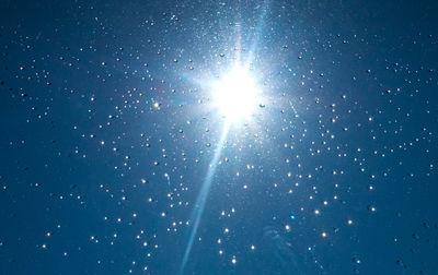 Low angle view of star field against clear blue sky
