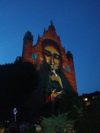 Low angle view of illuminated building against clear sky at night