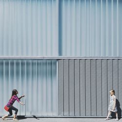 Sisters playing on footpath during sunny day