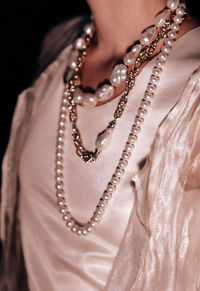 Silver and pearl jewelry beads hanging on a woman's neck