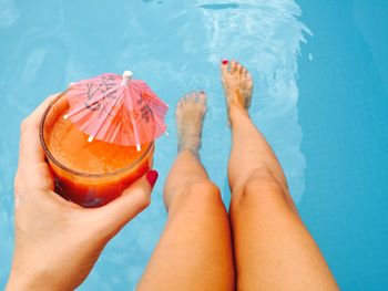 Low section of woman's legs in swimming pool