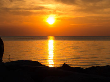 Scenic view of sea against orange sky