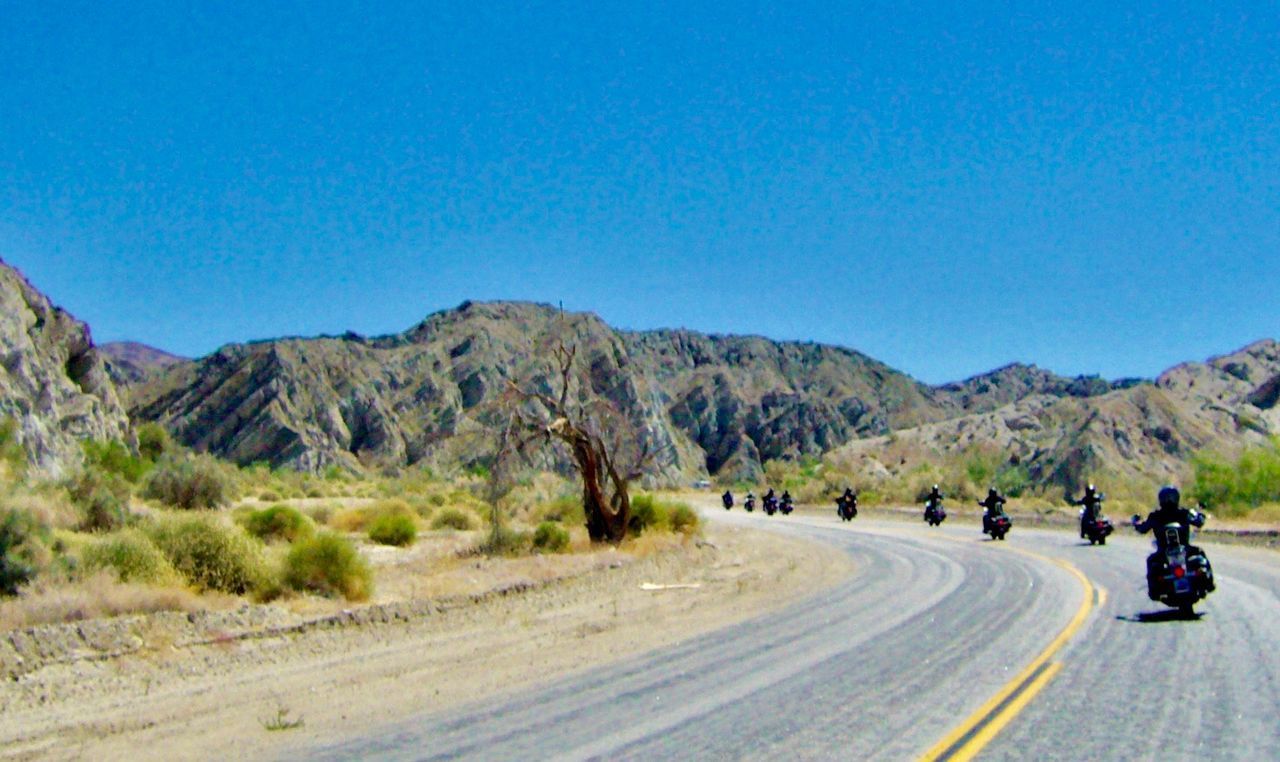 ROAD AMIDST LANDSCAPE AGAINST CLEAR BLUE SKY