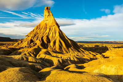 Scenic view of rock formation on arid landscape against sky