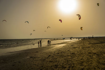 People at beach during sunset