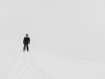 Rear view of person skiing on snowcapped mountain