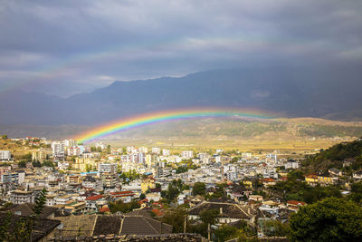 Aerial view of rainbow over city against sky