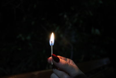 Human hand holding lit candle