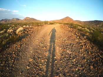 Shadow of man on field against sky