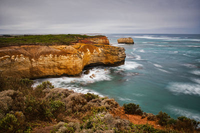Scenic view of rocks on sea against sky
