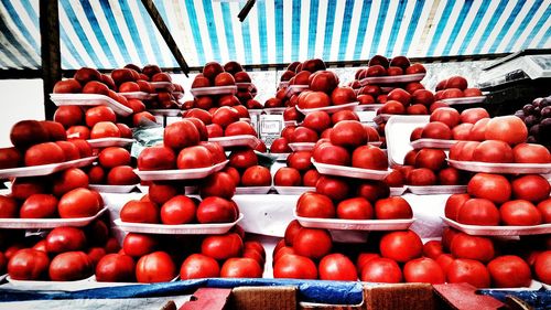 Stack of tomatoes for sale at market stall