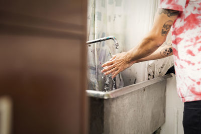 Cropped image of man washing hands