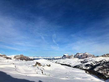 Scenic view of snowcapped mountains against blue sky