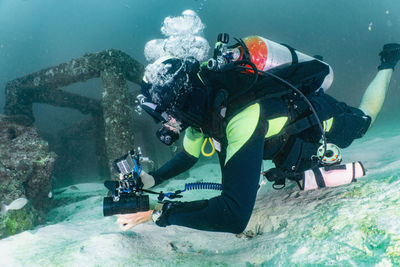 Diver exploring an artificial reef structure at raja yai / phuket