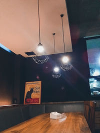 Illuminated pendant lights hanging on table at home