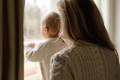 Mother and son near window at home