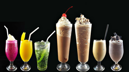 Various drinks against black background