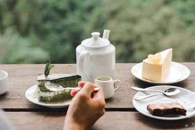 Midsection of man holding coffee cup on table