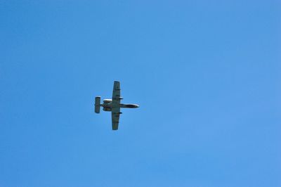 Low angle view of airplane against clear blue sky