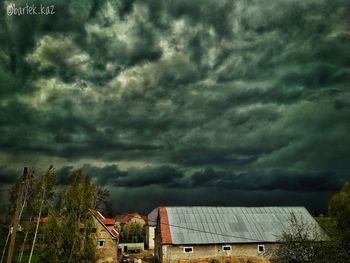Scenic view of storm clouds over houses
