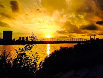 Bridge over river at sunset