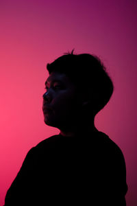 Close-up portrait of silhouette man against pink background