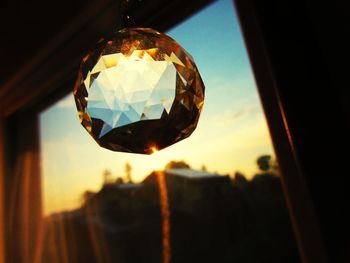 Low angle view of illuminated lamp against sky at sunset