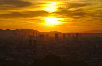 Silhouette buildings against sky during sunset