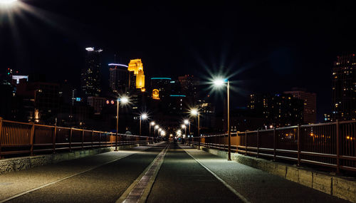 Illuminated bridge in city at night