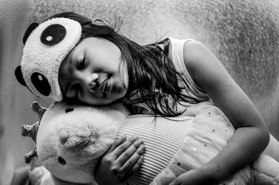 High angle view of young girl lying on bed in black and white