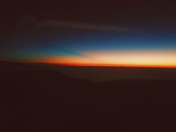 Scenic view of silhouette mountain against sky at sunset