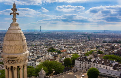 Aerial view of cityscape against cloudy sky