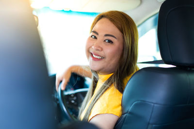 Portrait of a smiling young woman in car